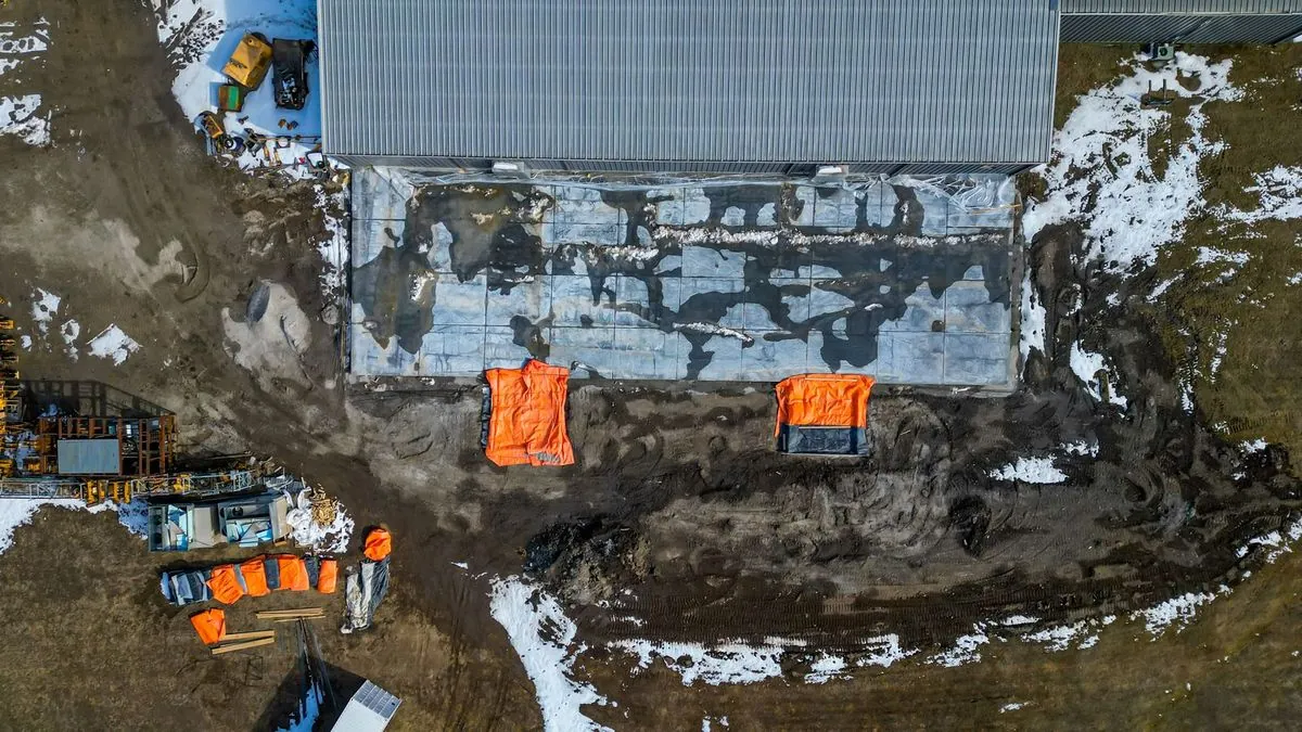 Abstract top-down view of jobsite with orange tarps in mud