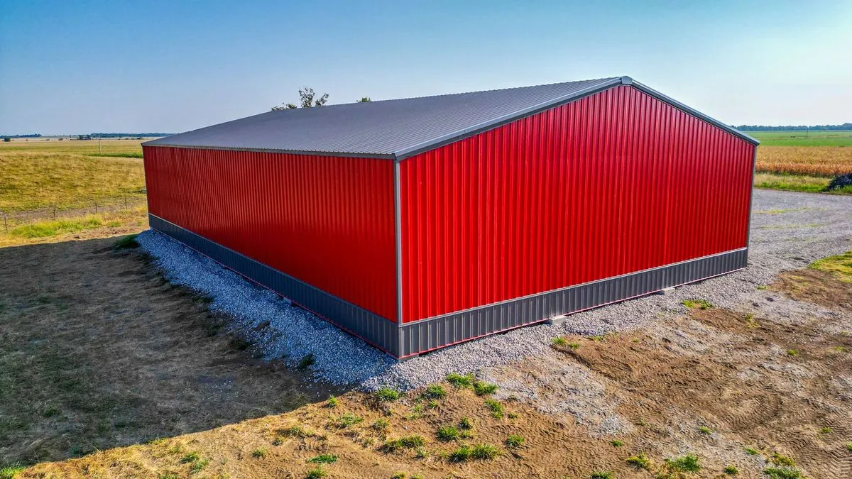 Completed red metal barn building in pasture