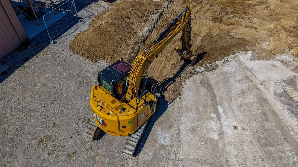 Top-down view of yellow excavator on gravel jobsite